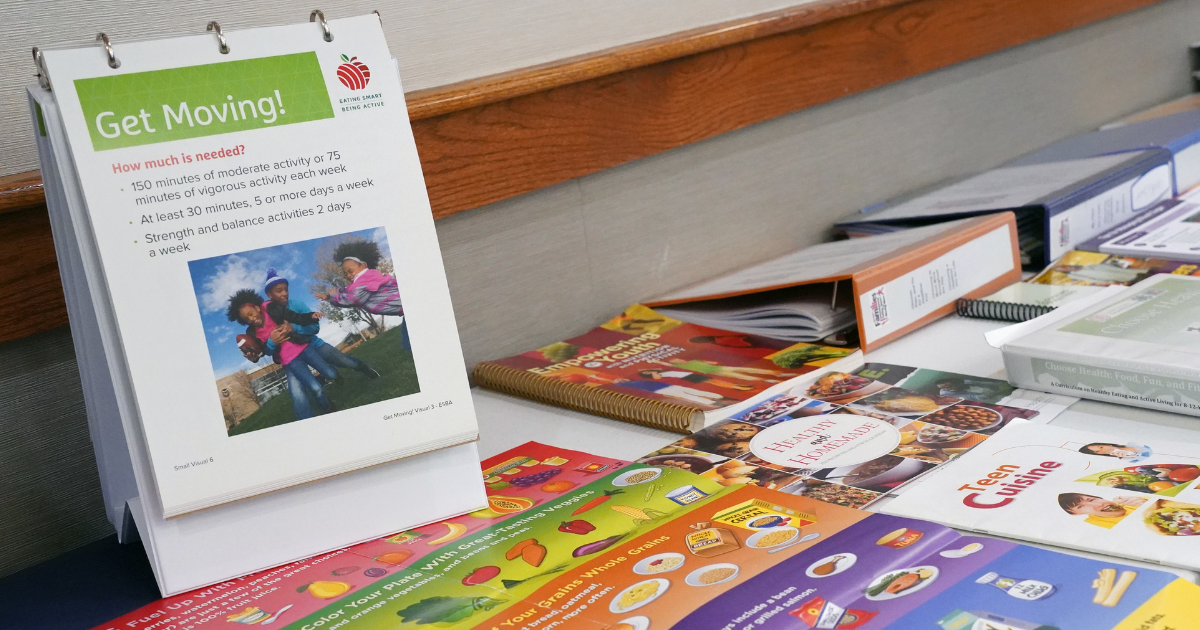 Health and nutrition informational display on a table, featuring colorful posters and booklets about physical activity and healthy eating.