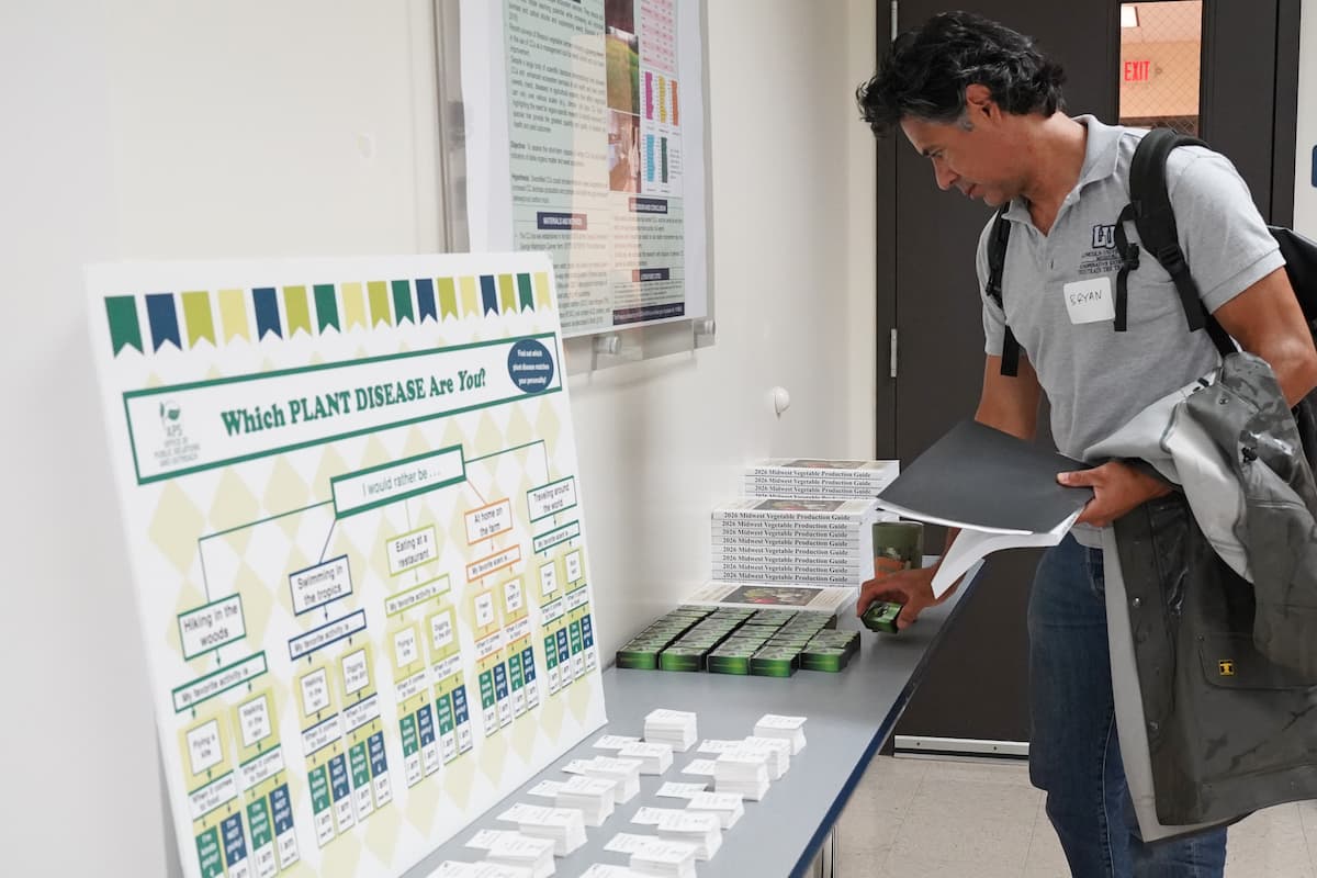 A man picks up a small box from a table full of items.
