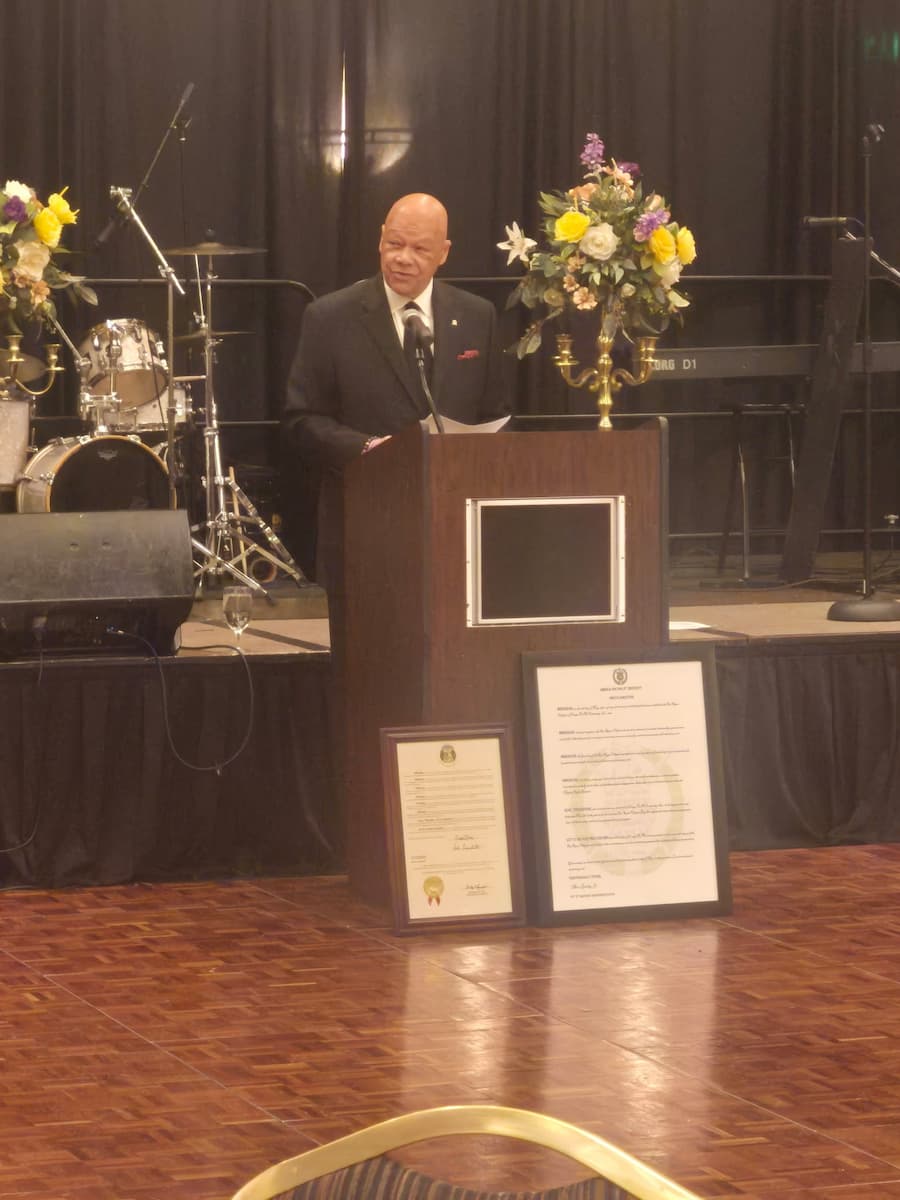 A man dressed in a suit stands at a podium while giving a speech.