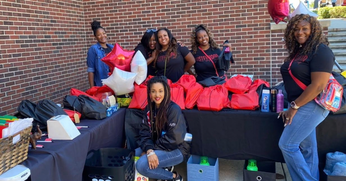 A group of women fill up bags with tolietry items for students.