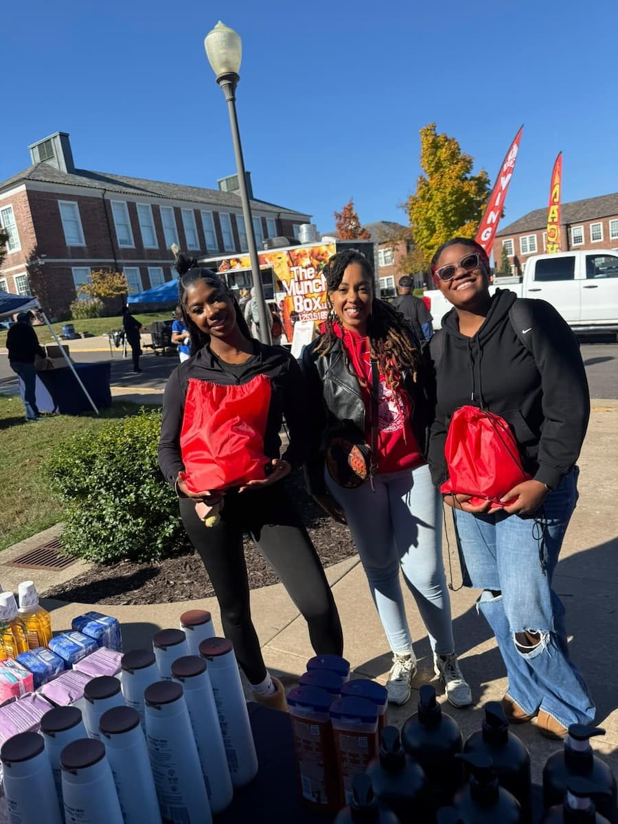 Lincoln University students accept red drawstring backpacks from the 36 Divas.