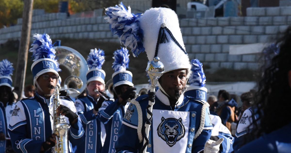 Students in blue and white Marching Band uniforms march during the Homecoming 2026 parade.