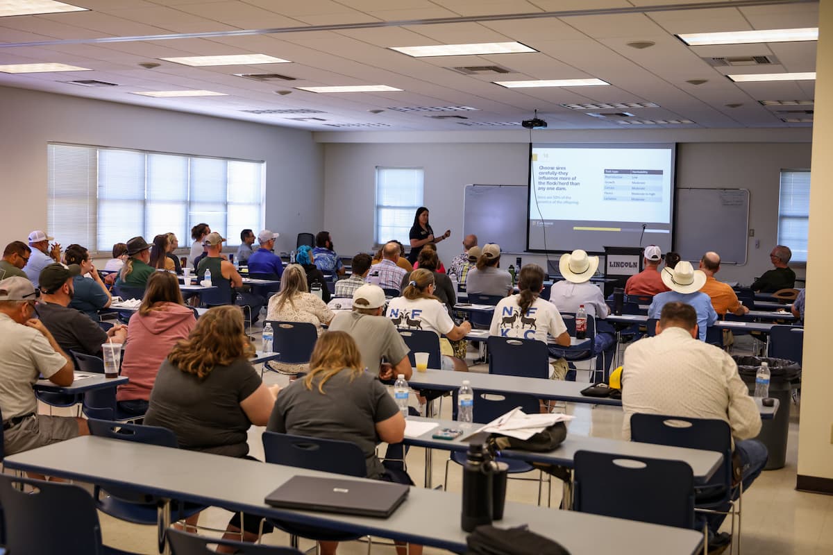 A classroom of participants listens to a presenter speaking at the front of the room during Small Ruminant Field Day.