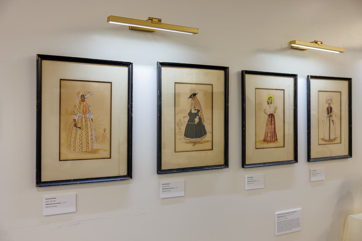 Four paintings in a row hang up at an art exhibit.