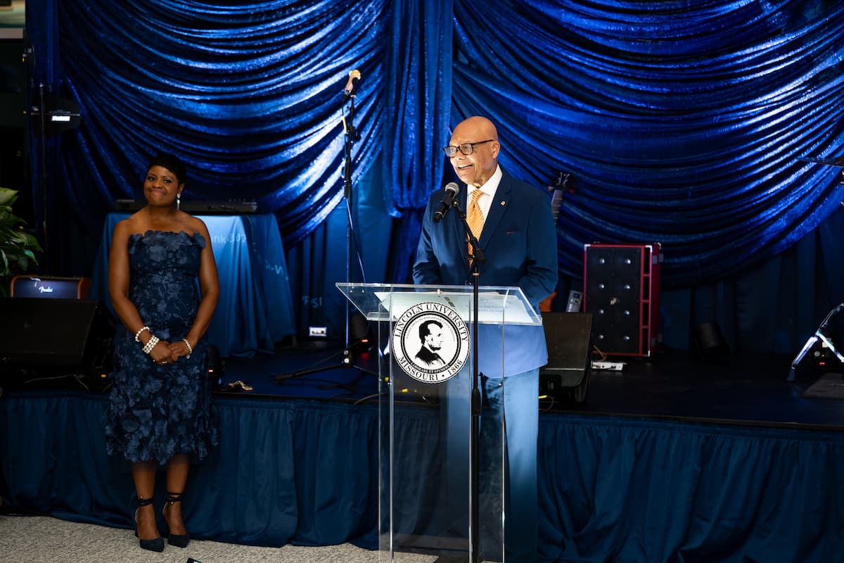 A man in a suit stands at a podium while giving a speech.