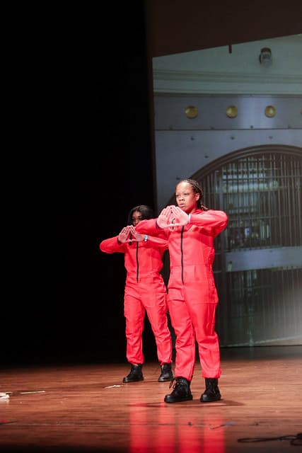 Two members of Lincoln University of Missouri's Delta Sigma Theta perform on stage during a Homecoming step show. 